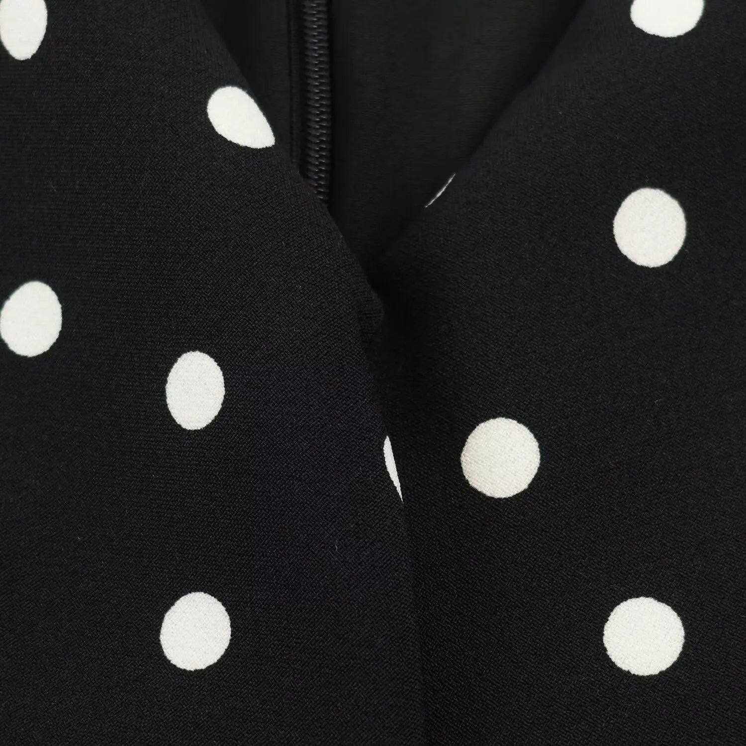 Close‑up v‑neck seam and concealed back zipper on polka dot midi dress