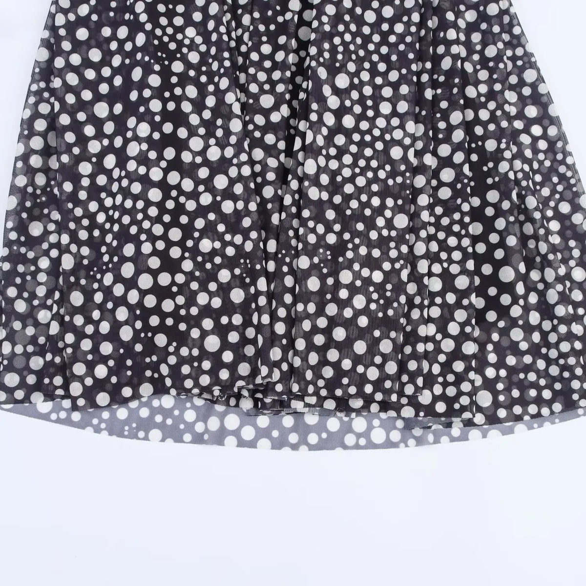 Close-up of black mesh fabric with white polka dots and light grey lining edge