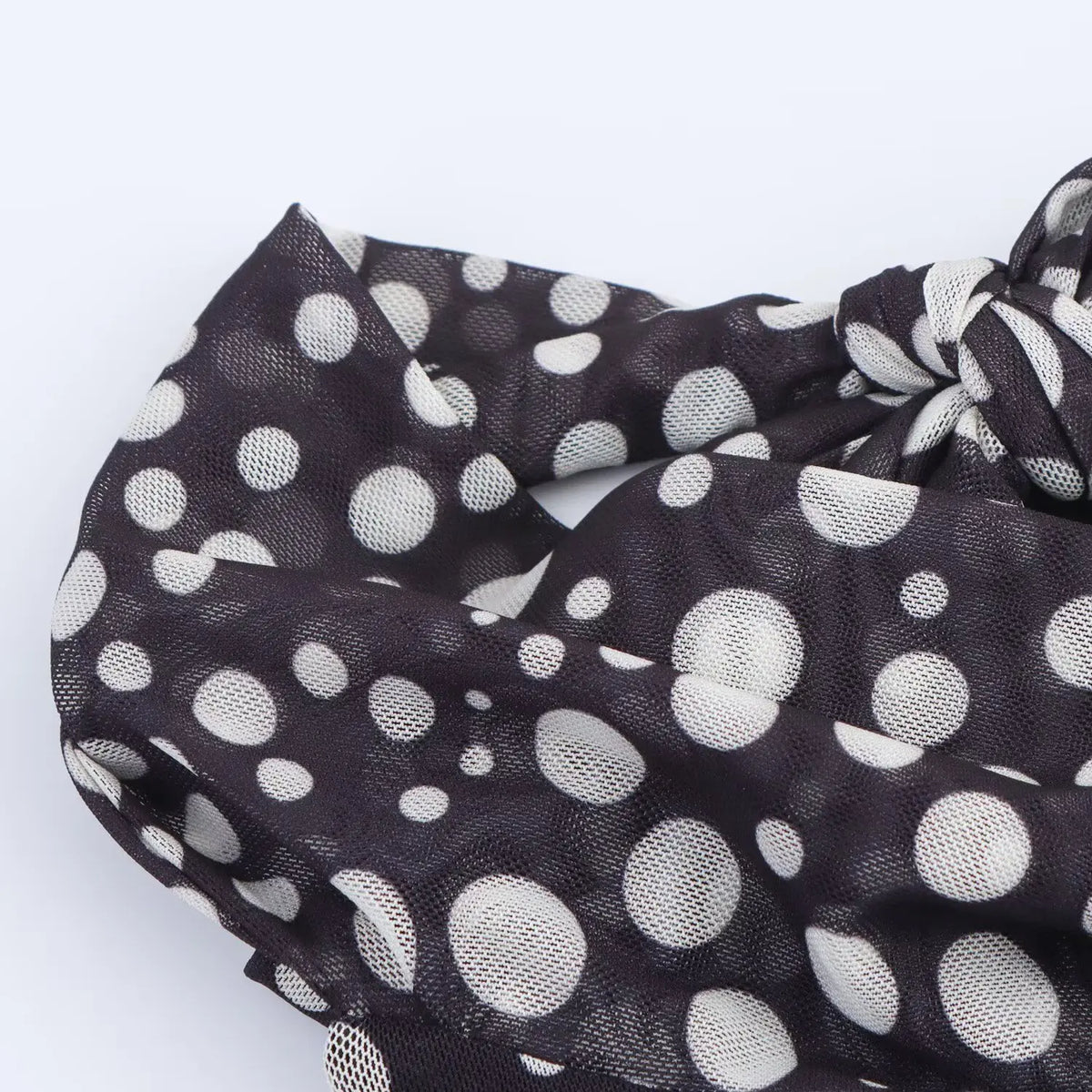Close-up of knotted polka dot mesh tie straps in matching fabric