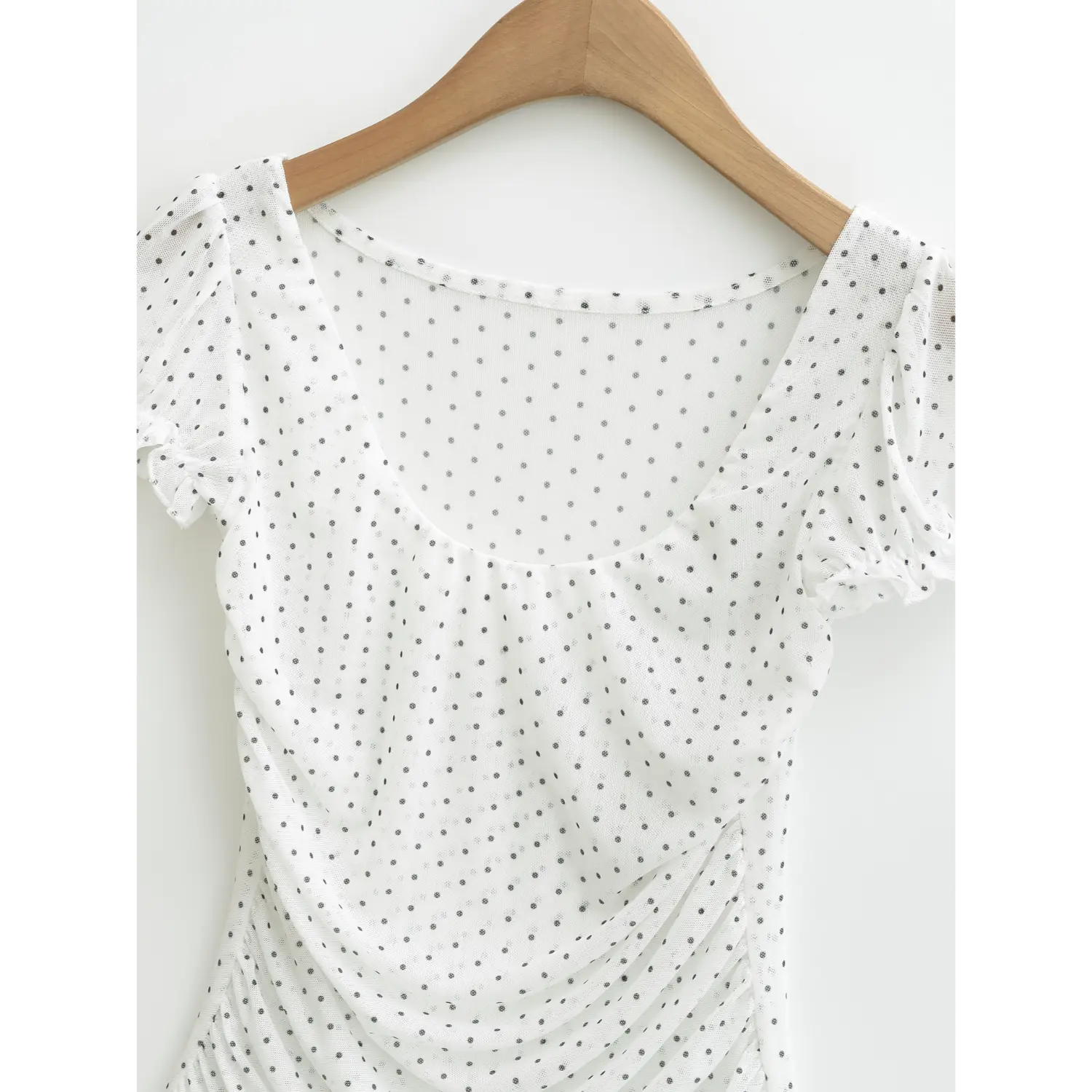 Close up of square low scoop neckline, white sheer mesh polka dot top with ruffled puff sleeve cuffs