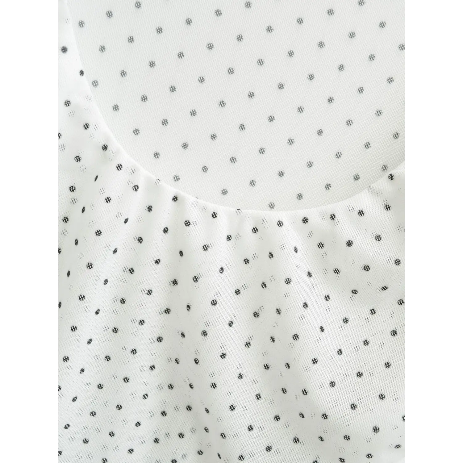 Extreme close-up of wide square scoop neckline on white sheer mesh polka dot blouse, stretch mesh fabric texture with scattered black dots