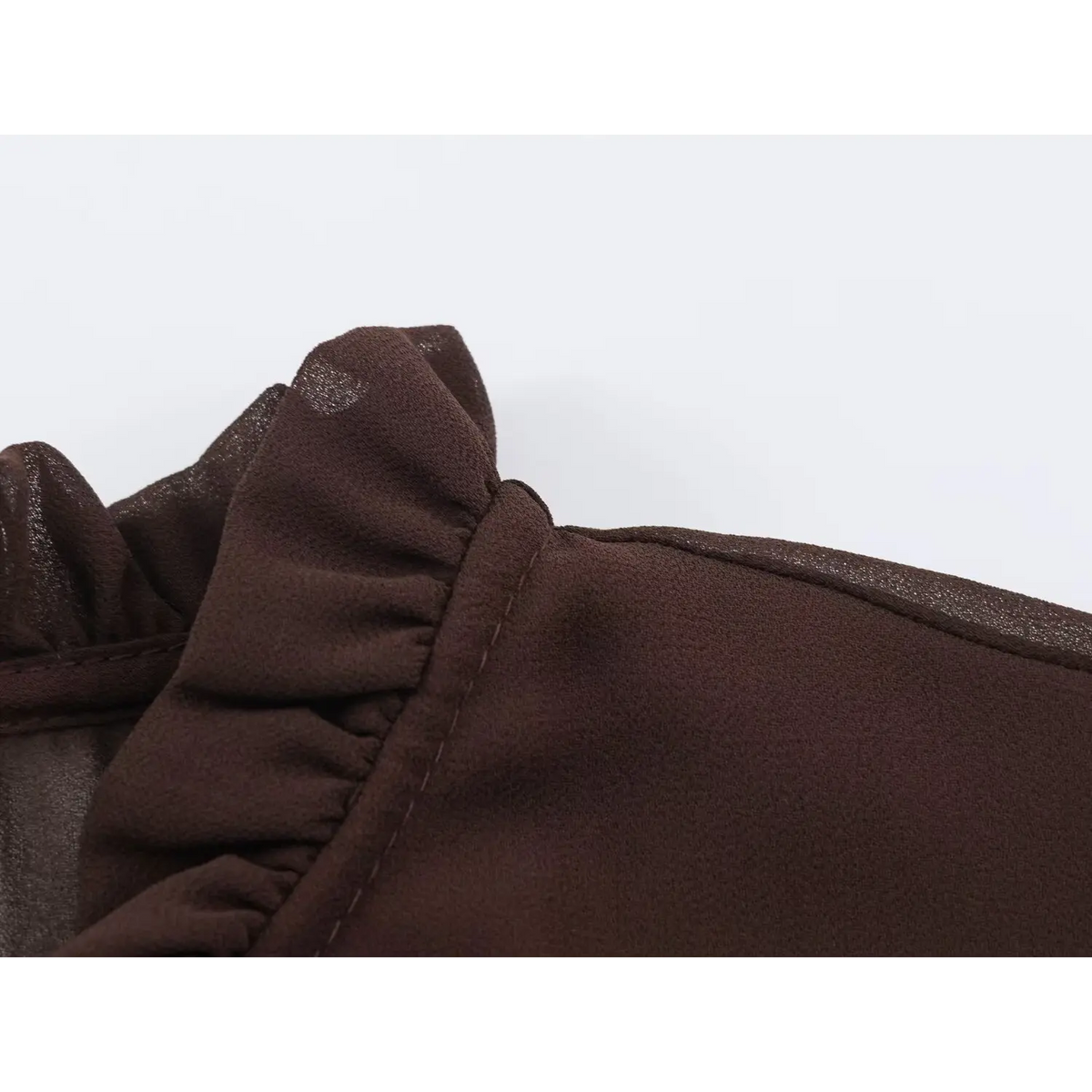 Close-up of ruffled neckline edge and shoulder seam