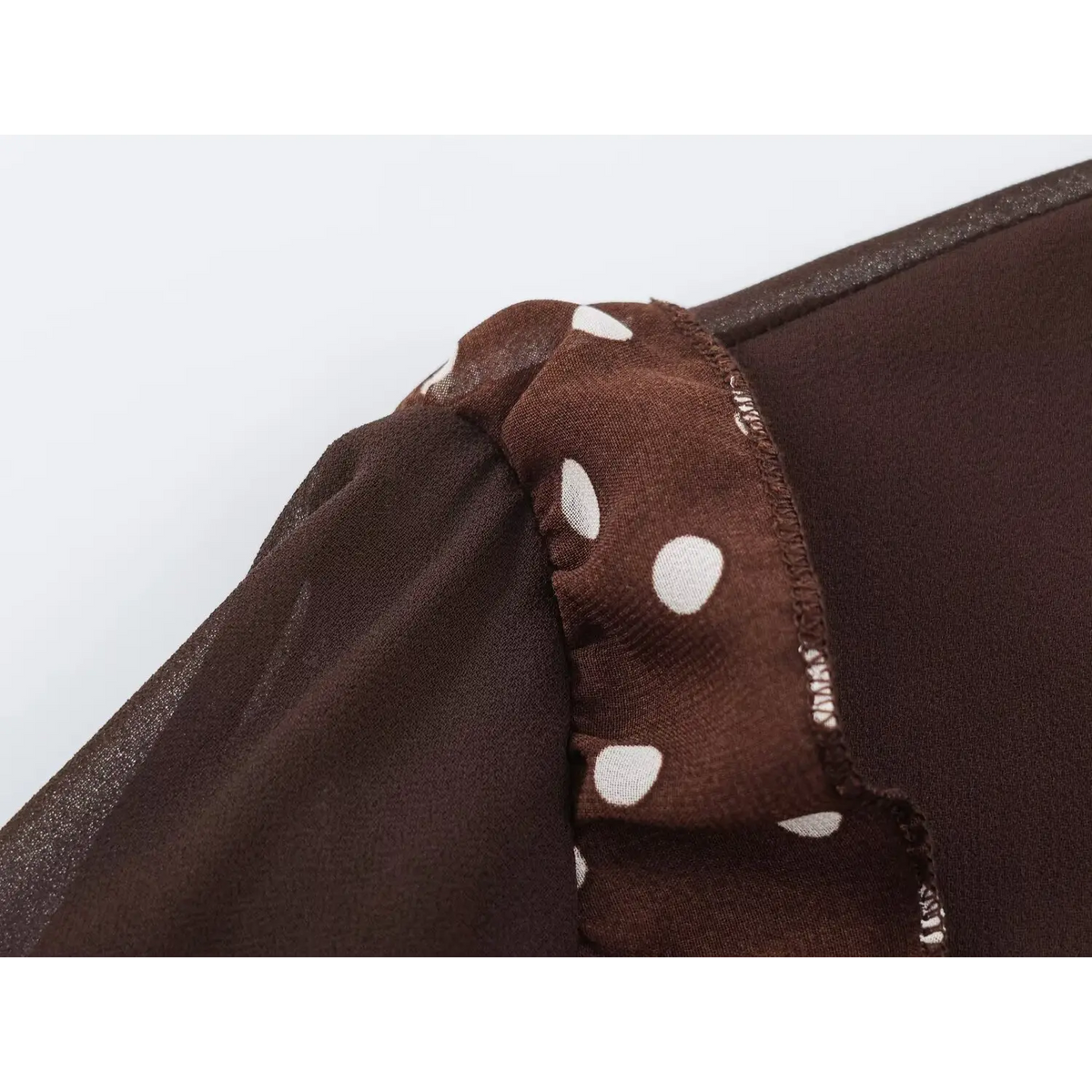 Close-up of polka dot shoulder ruffle and overlock stitching