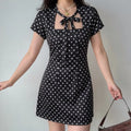 Model wearing black polka dot tie neck short sleeve mini dress