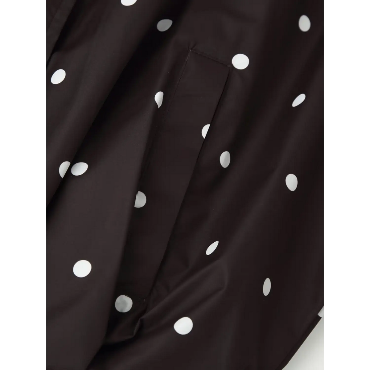 Close‑up of side pocket detail on black white polka dot windbreaker