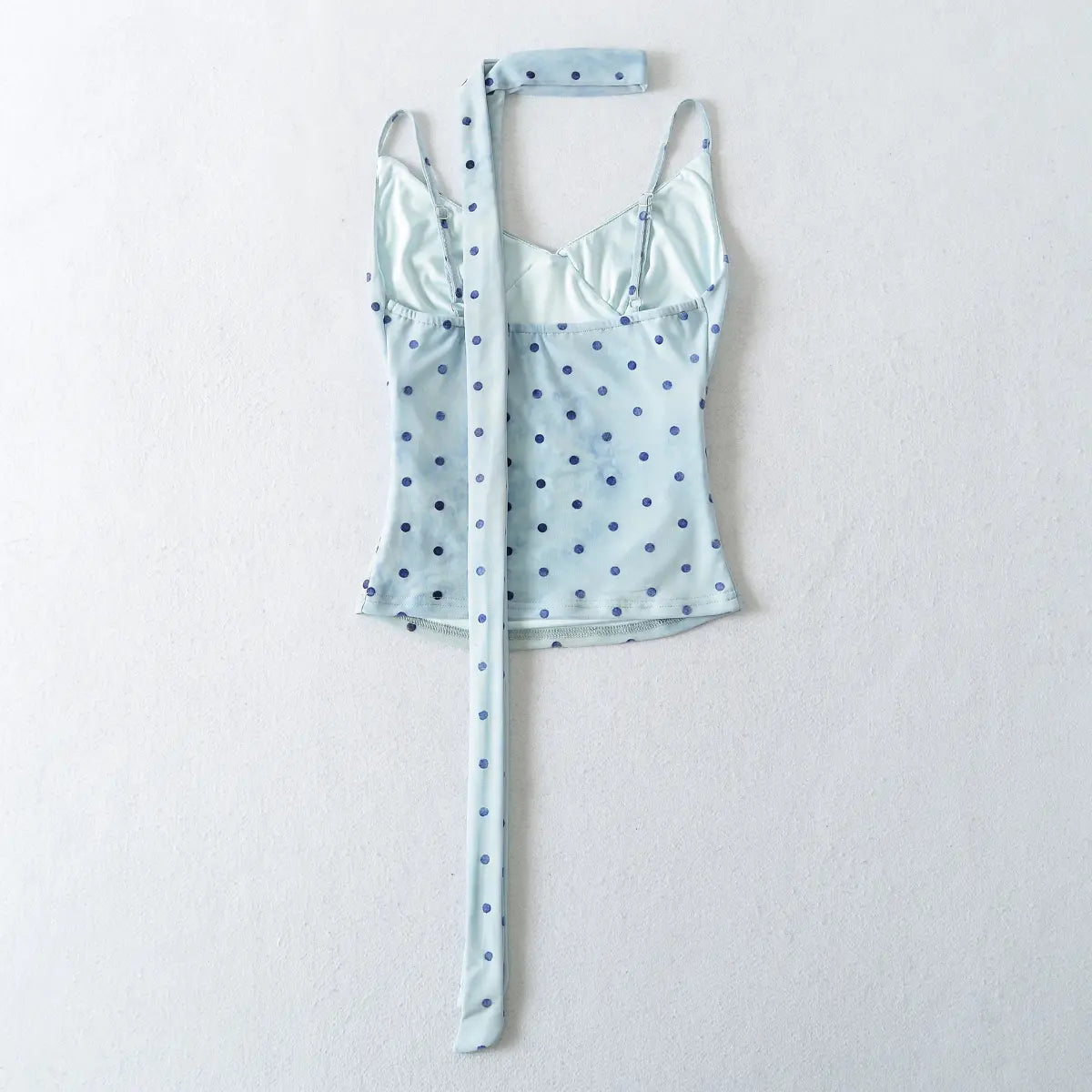 Light blue polka dot top with matching belt on a white background