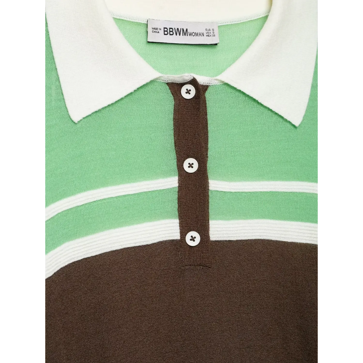 Close‑up henley button placket, white round buttons, inner clothing label tag detail
