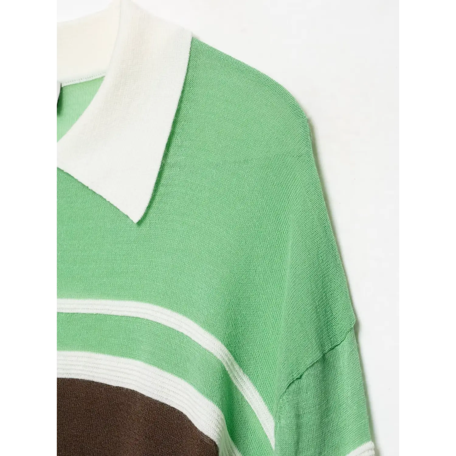 Shoulder seam close‑up, fine lightweight green knit texture, relaxed dropped shoulder