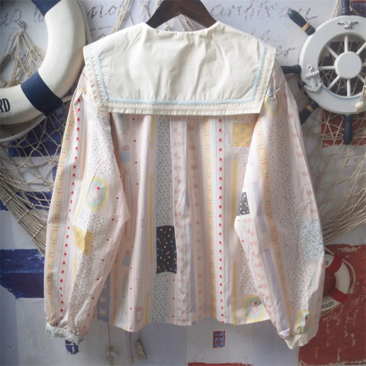 Cartoon print sailor collar blouse full back hanging shot, full cream wide sailor lapel full vertical cartoon stripe print loose dropped shoulder straight silhouette back simple soft style display