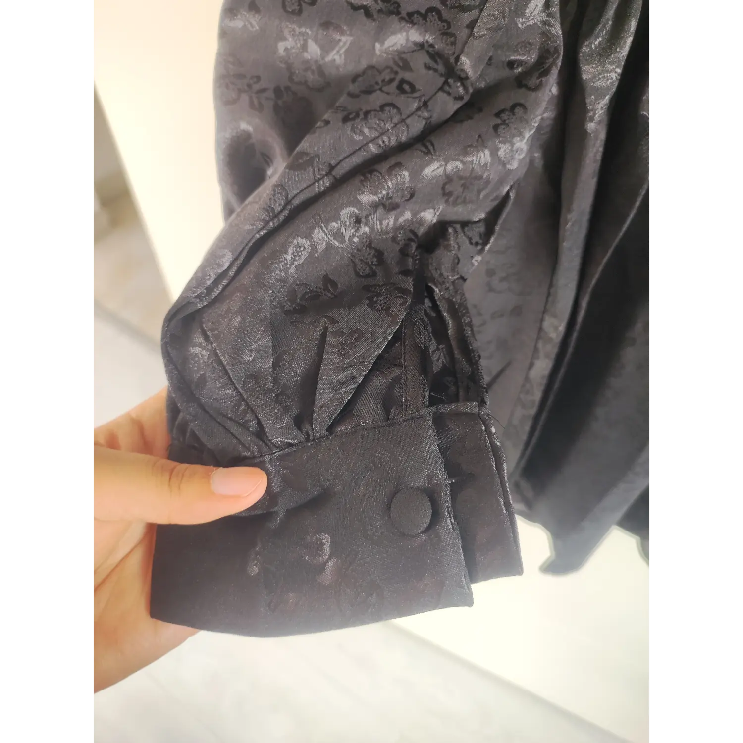 Long sleeve placket with fabric covered button cuff, black floral jacquard dress detail | Detail