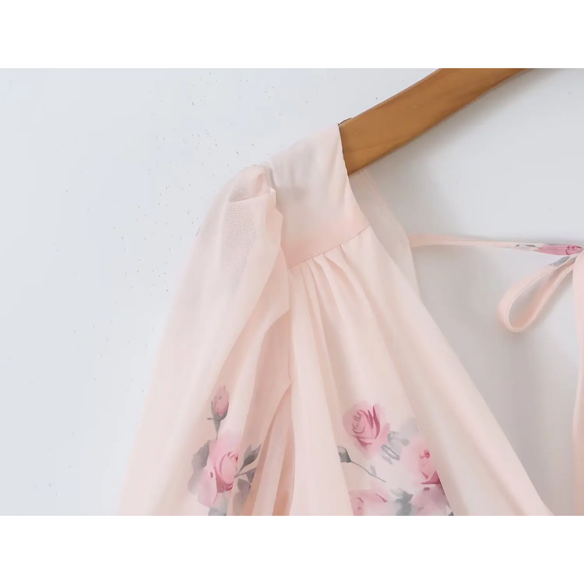 Close-up of dress puff shoulder part, pink rose printed chiffon fabric with gathered shoulder design