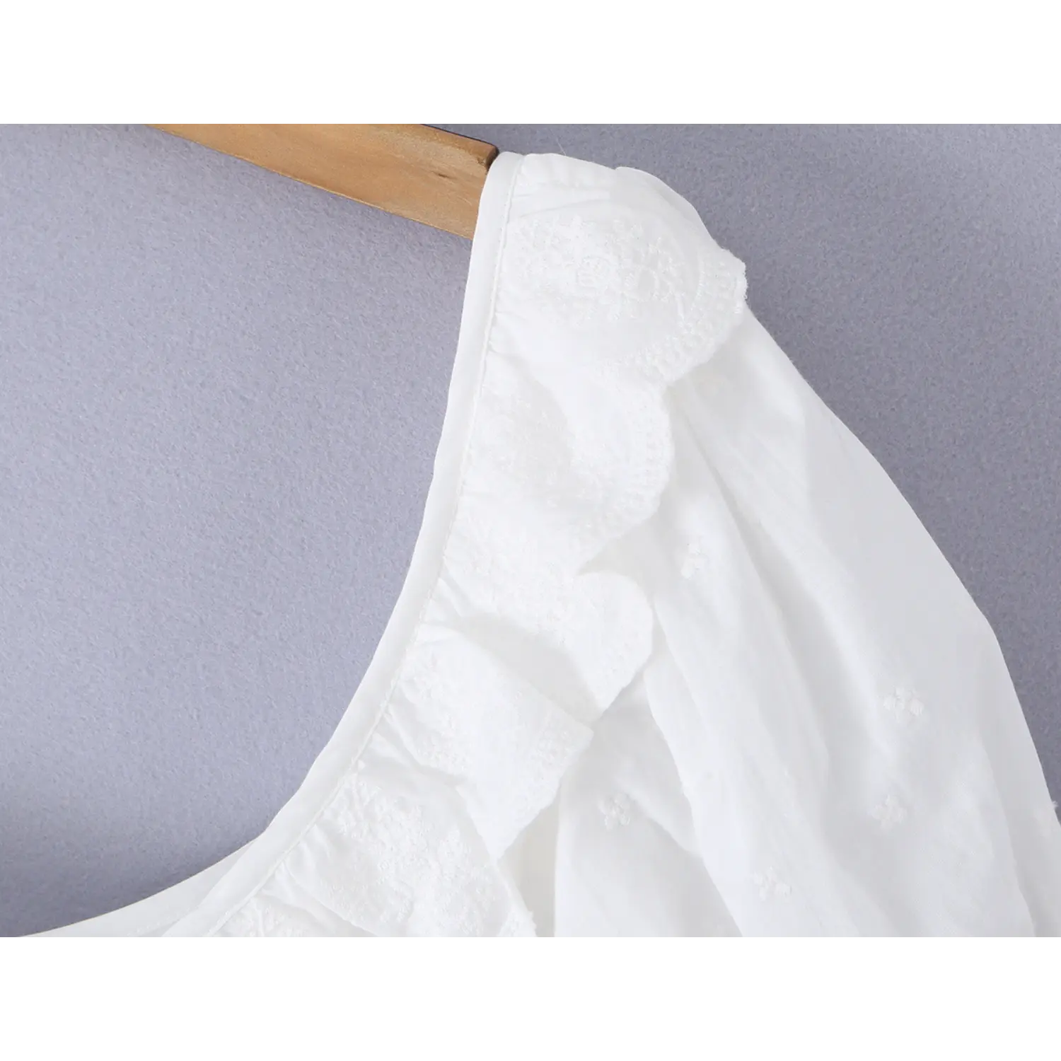 Shoulder close up delicate embroidered lace ruffle trim on bubble puff sleeve white cotton corset top