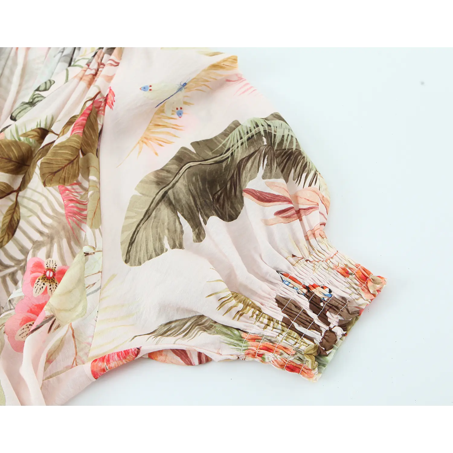 Closeup of 3/4 puff sleeve smocked cuff on pink tropical print midi dress