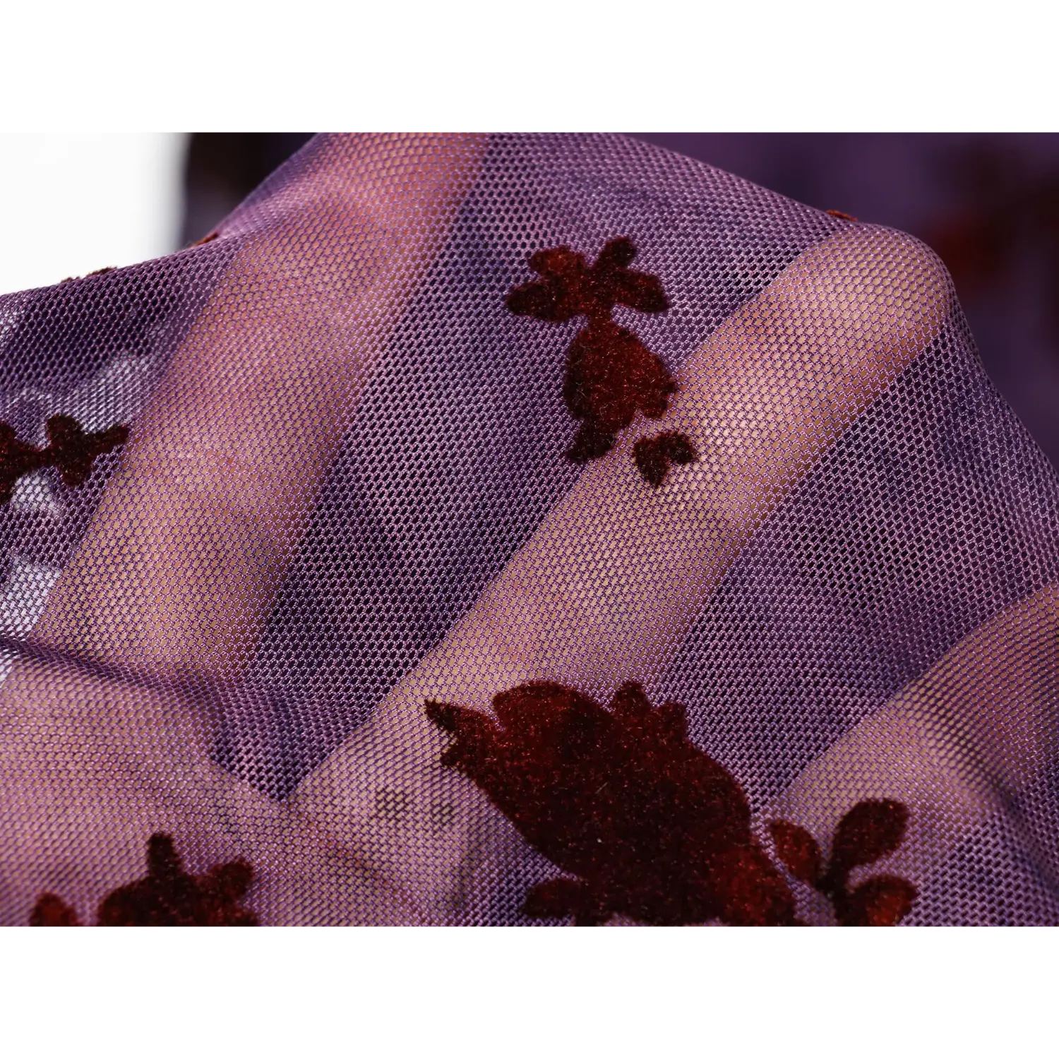 Macro fabric shot, sheer purple mesh with velvet flock burgundy floral print, translucent texture