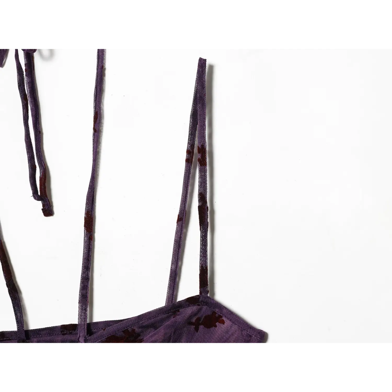 Macro shot of thin mesh spaghetti straps with burgundy floral pattern