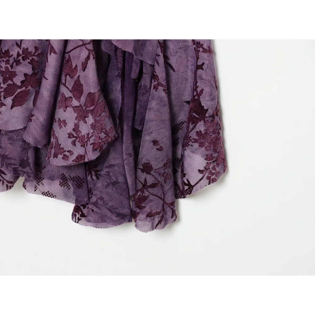 Close‑up layered ruffle hem, floral flock print mesh fabric of purple cami dress