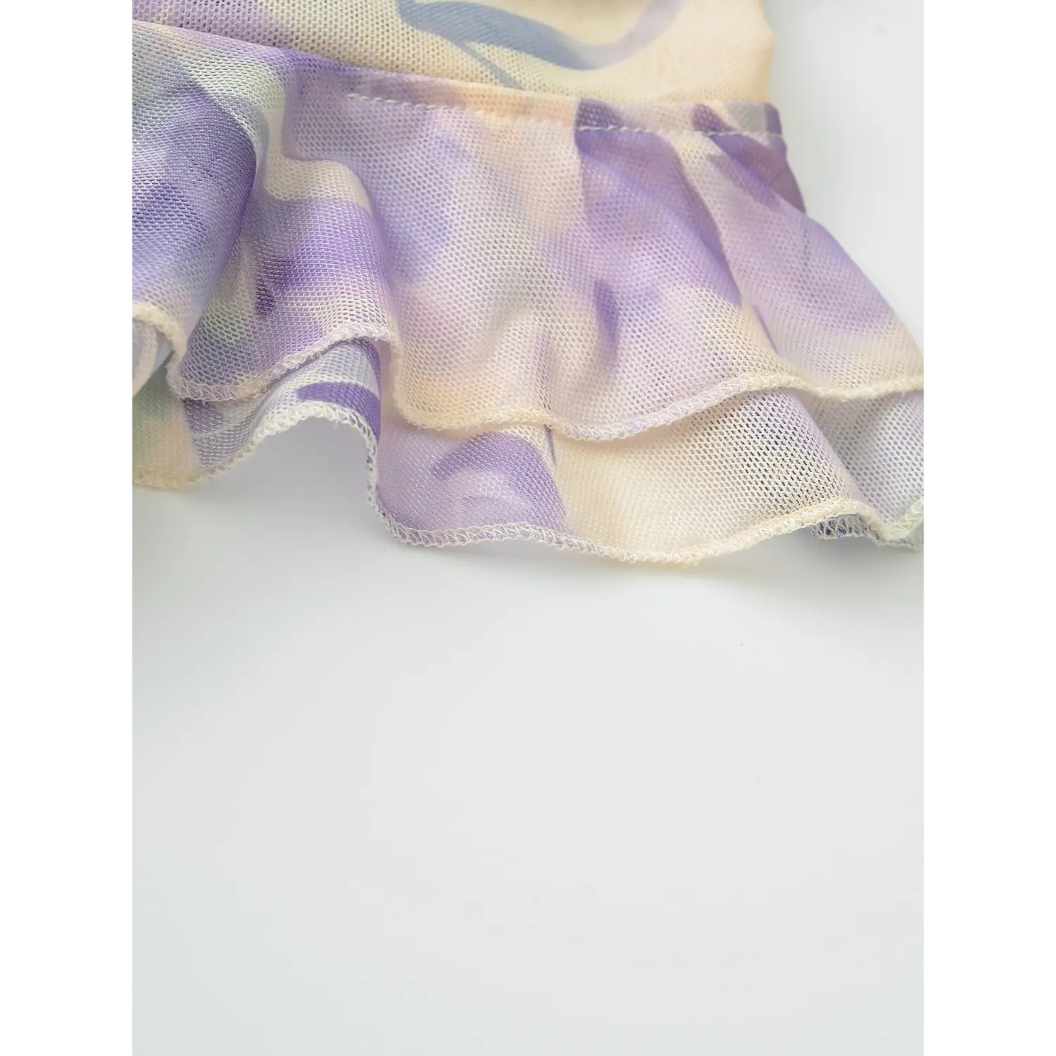 Purple floral mesh top double ruffle hem macro flat close-up, two-layer mesh flounce wavy elastic overlock breathable mesh print fabric white background craft shot