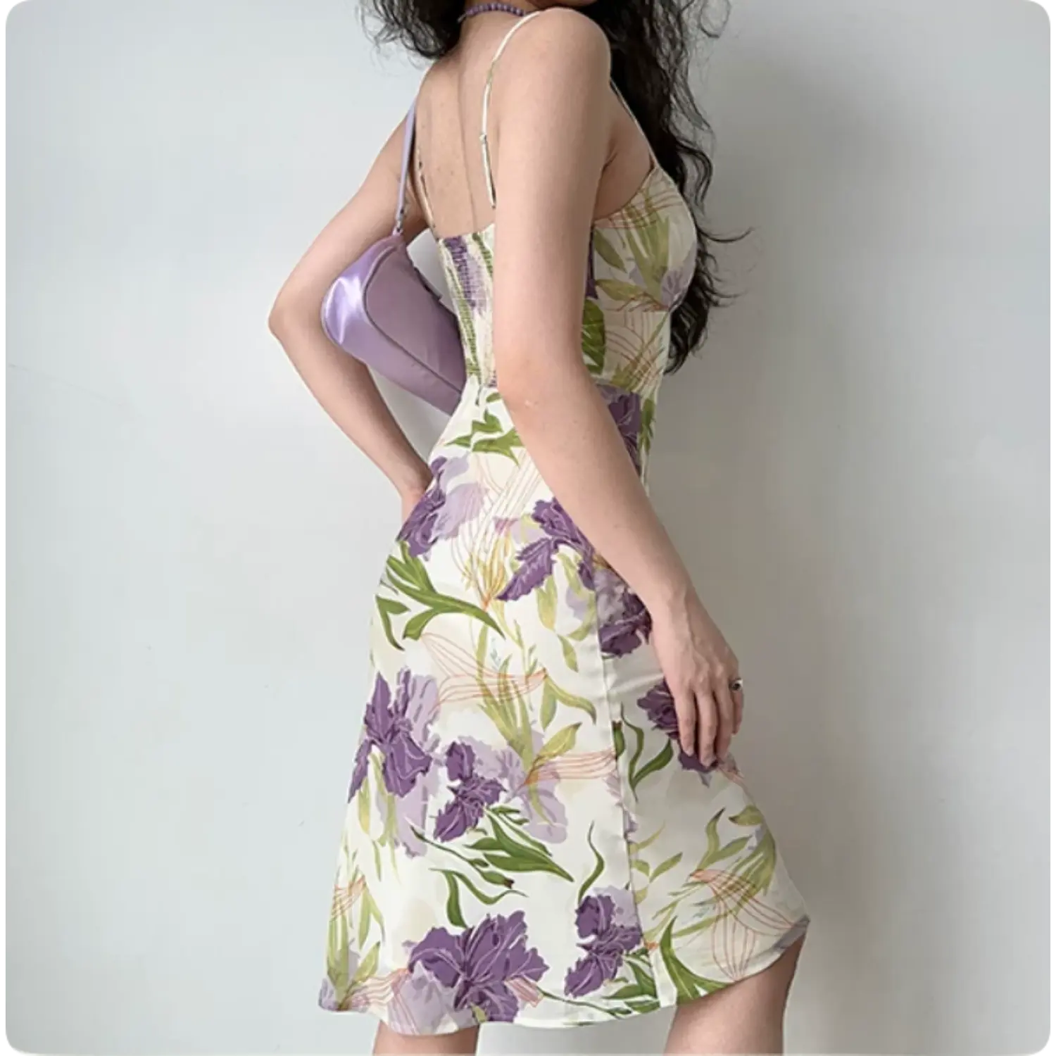 Model back three‑quarter view purple iris floral midi dress smocked back panel thin spaghetti straps form‑fitting skirt