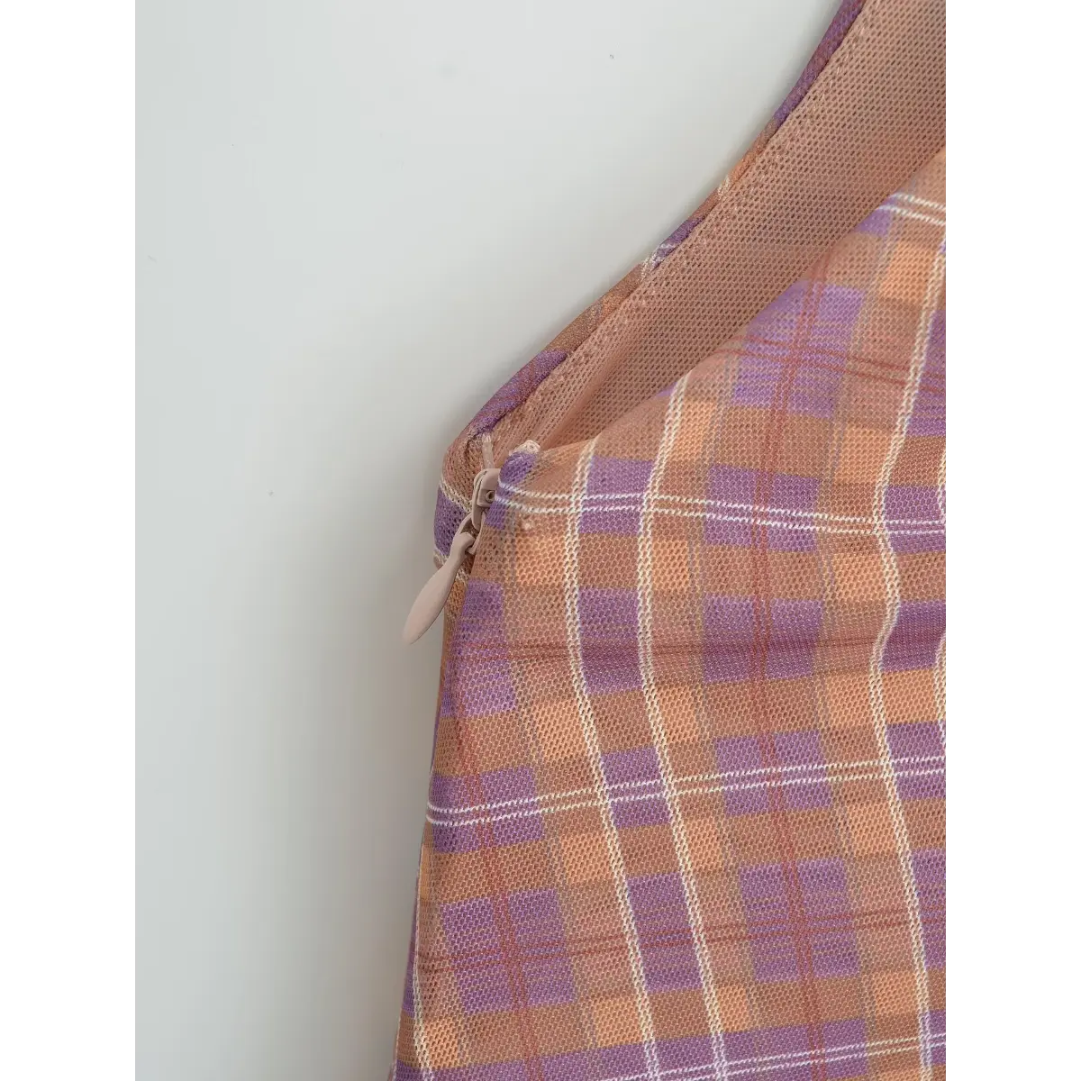 Close-up of the hidden side zipper with a nude-colored pull tab.