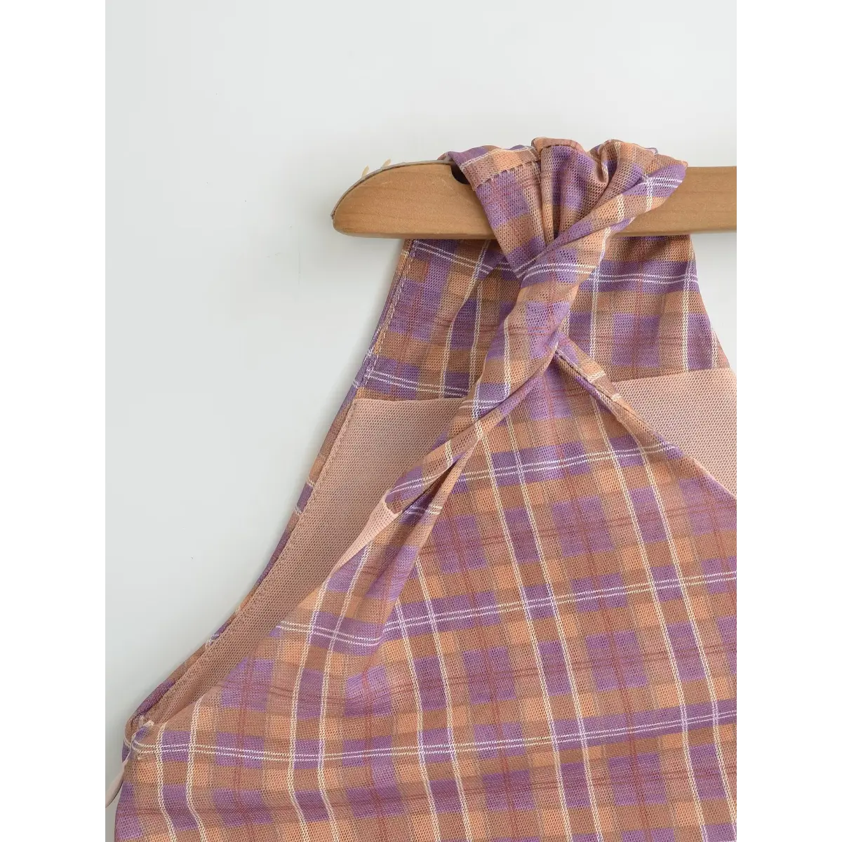 Close-up of the twisted shoulder strap, showing the sheer mesh texture and plaid print.