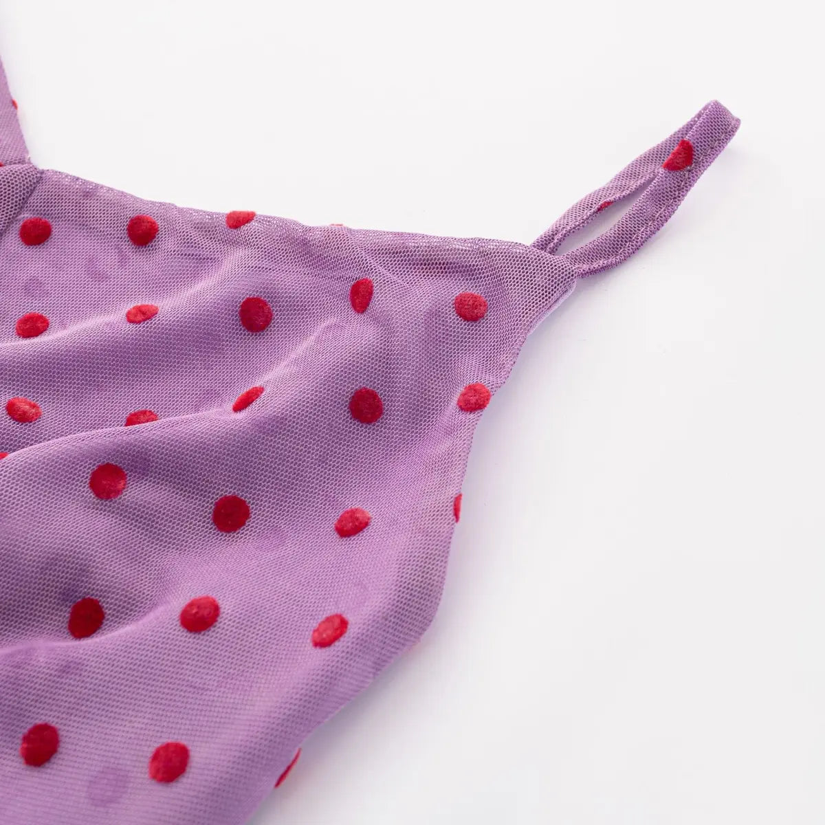 Close-up of the purple cami top's spaghetti strap, showing the mesh fabric with red polka dots and stitching
