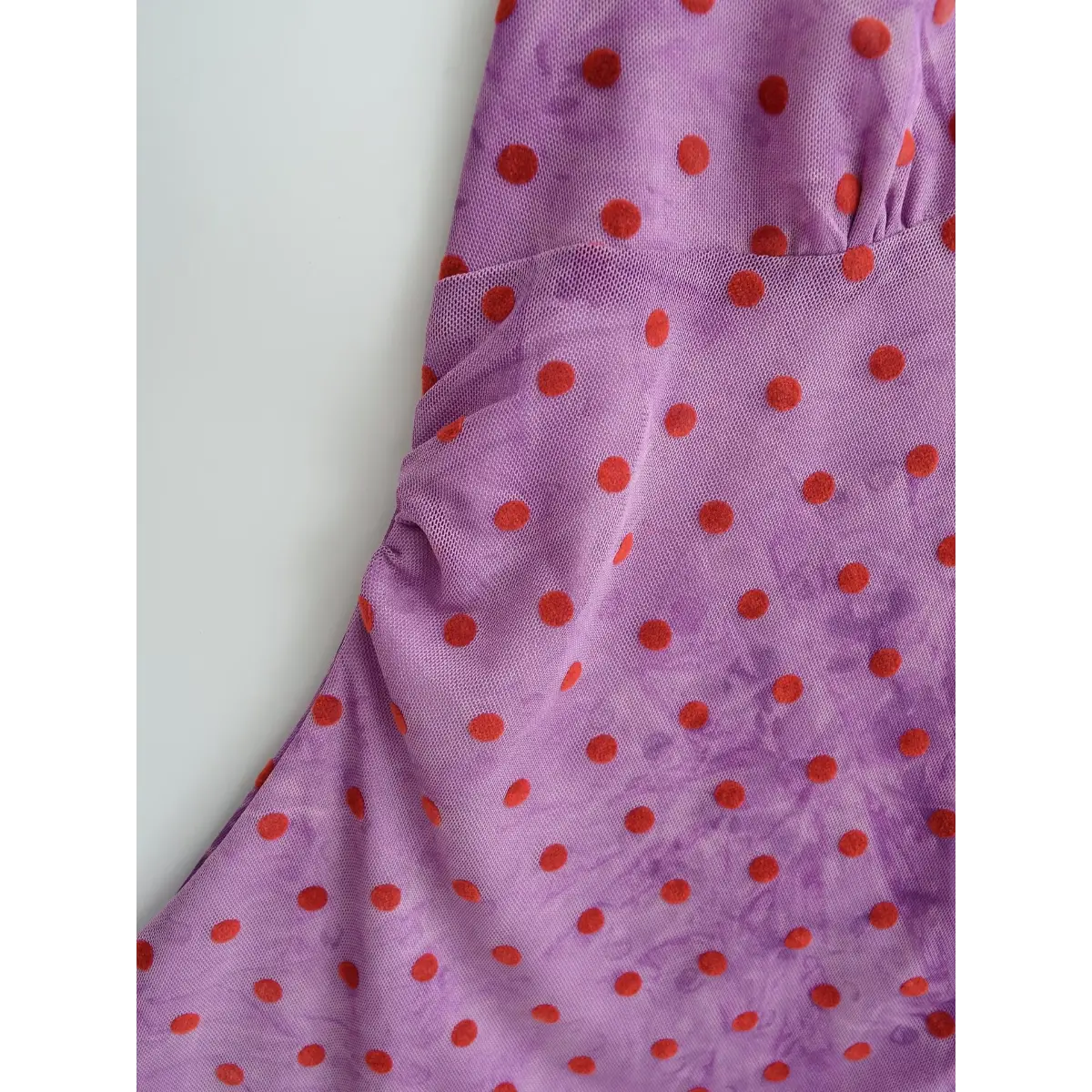 Close-up of the sheer mesh fabric, showcasing the watercolor-purple base with red polka dots and side ruched detail.