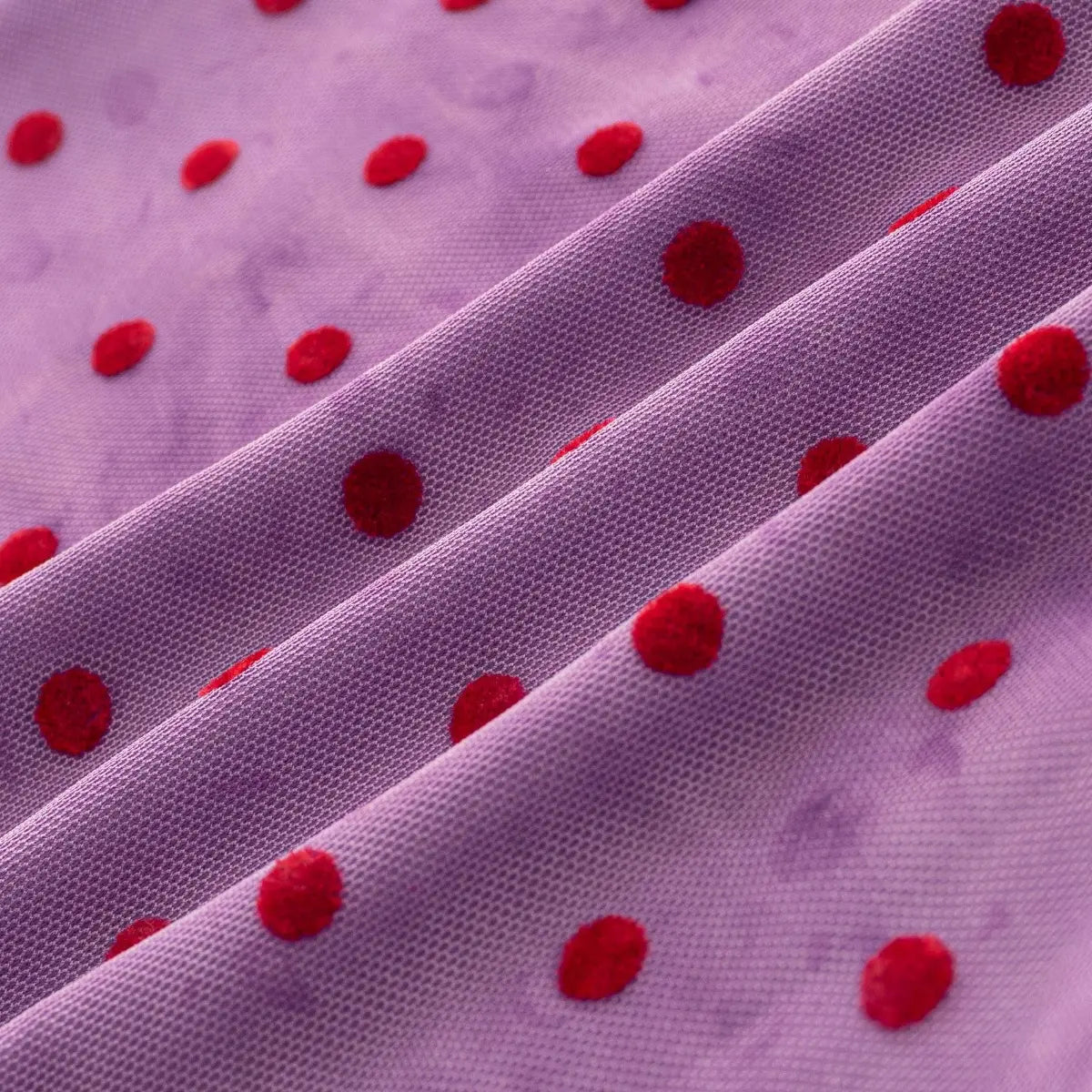 Close-up of the purple mesh fabric with red flocked polka dots, showing the texture and weave