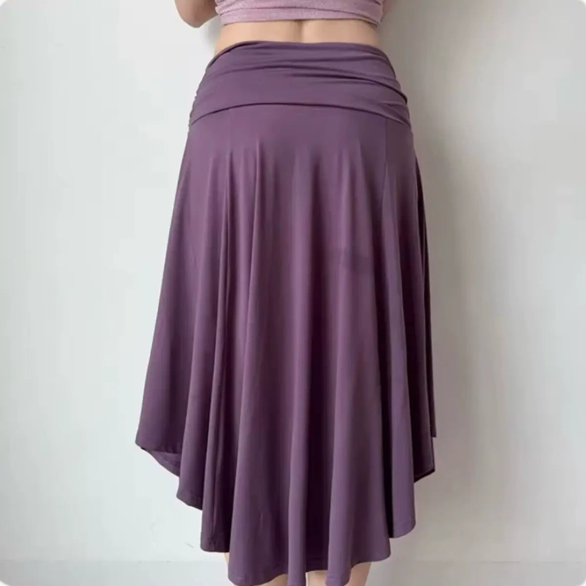 Back view of a purple asymmetrical midi skirt, highlighting the gathered waistband and fluid, handkerchief-style hem.