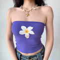 Close-up of the purple strapless tube top, highlighting the plumeria print and ribbed texture.