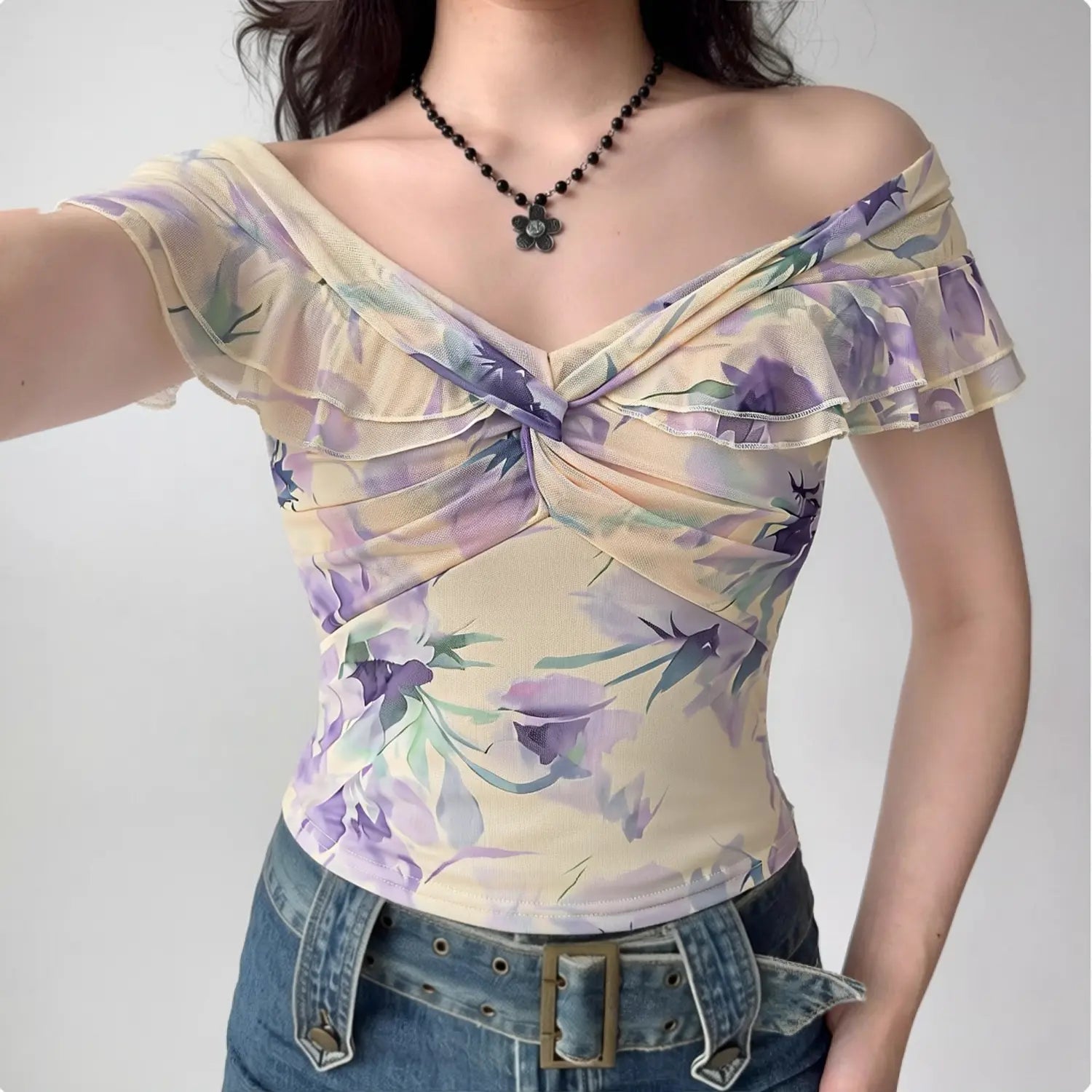 Purple watercolor floral mesh off shoulder top half body model shot, low saturation light purple print double ruffle front twist cropped feminine top shot