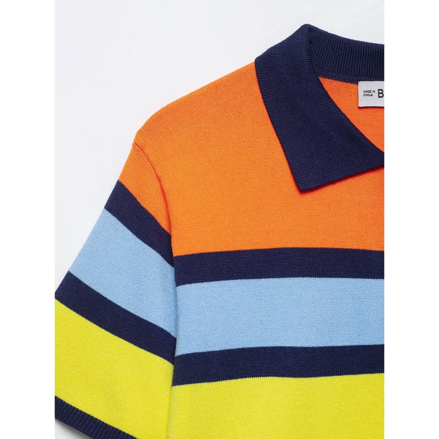 Shoulder & polo collar closeup, inner woven size label, navy rib lapel trim, orange light blue yellow color block stripe knit weave