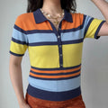 Lifestyle model wearing striped knit polo top, navy lapel collar, half shell button placket, slim fit silhouette, matching casual bottom outfit, retro color block rainbow stripe design