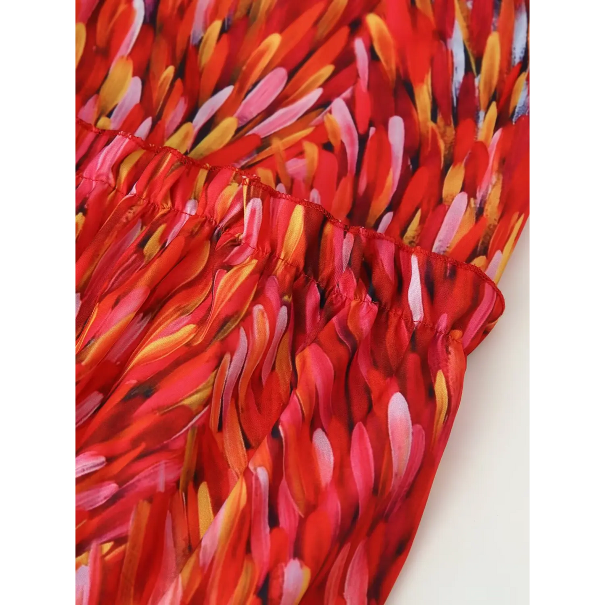 Close‑up skirt tier ruffle hem detail red abstract brushstroke print maxi dress