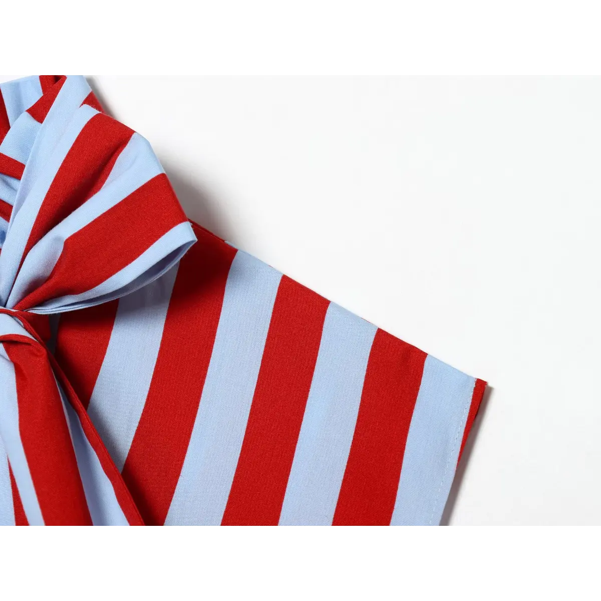 Close-up of the top's armhole and bow detail.