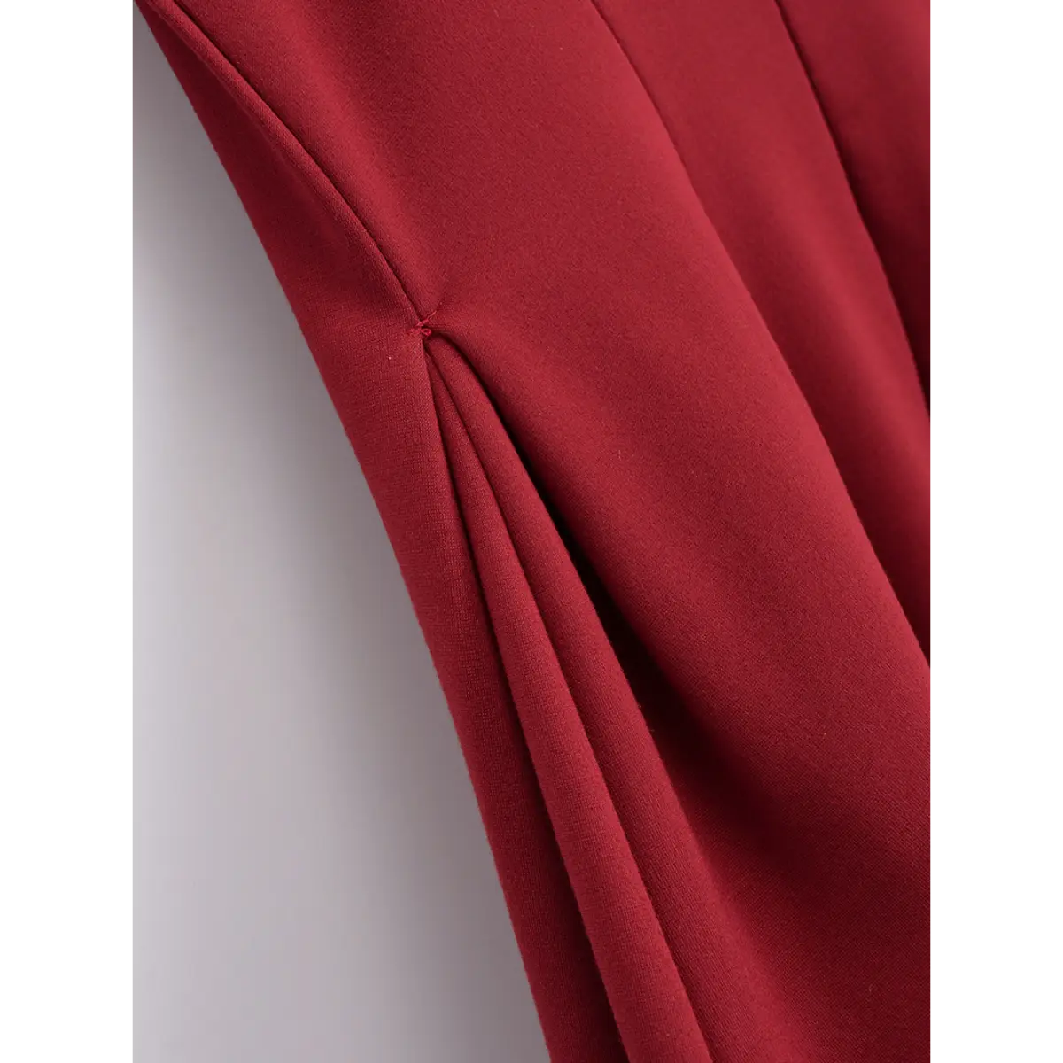 Close-up of the tailored side seams and fitted waist on the red cami dress