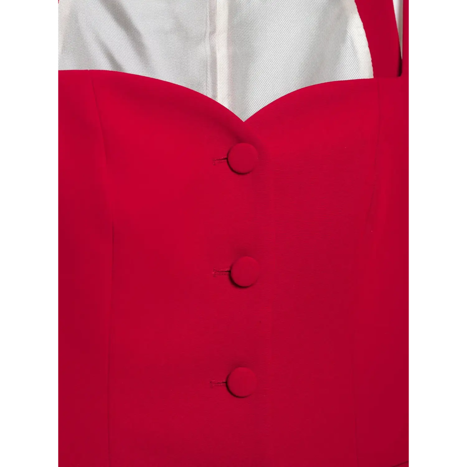 Macro close‑up of red fabric covered front buttons on red cami top, tailored suiting material, neat stitching detail, white background