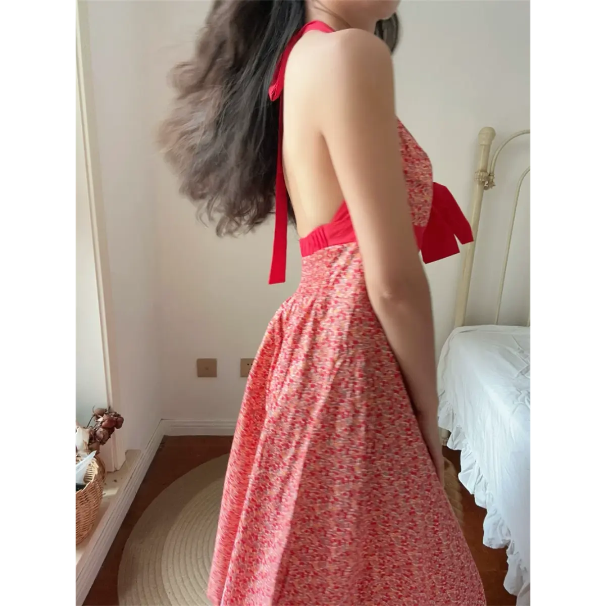 Side back lifestyle photo of cherry floral halter dress, open back with red halter neck tie and elasticated waist detail.