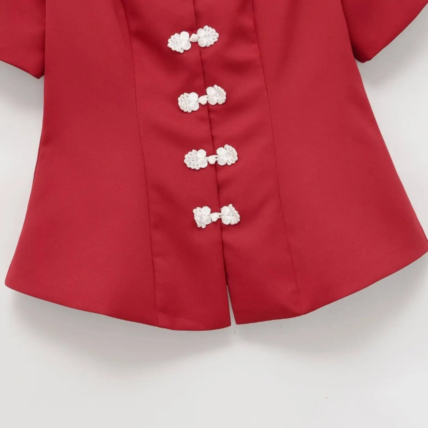 Close-up view of white frog buttons and peplum hem on red new chinese short sleeve top