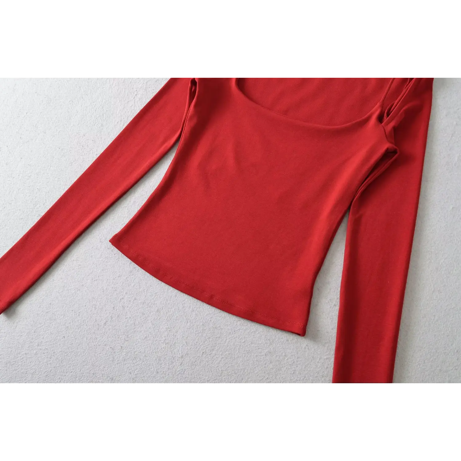 Red off shoulder long sleeve top hem flat close-up, slim waist double line overlock soft stretch knit neat binding stitching white background shot

