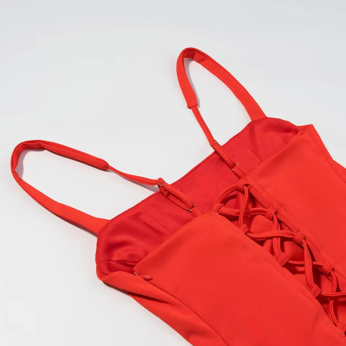 Close-up of the back lace-up closure on the red corset-style mini dress, showing the crisscross lacing and adjustable straps
