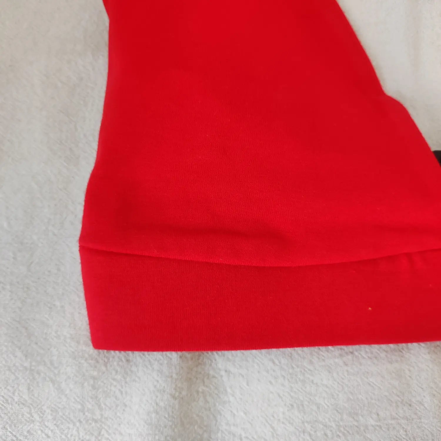 Close‑up of bottom hem band and soft knit fabric texture on red halter triangle crop top