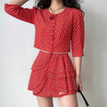Model wearing red ditsy floral co‑ord set, cropped puff sleeve top and tiered ruffle mini skirt