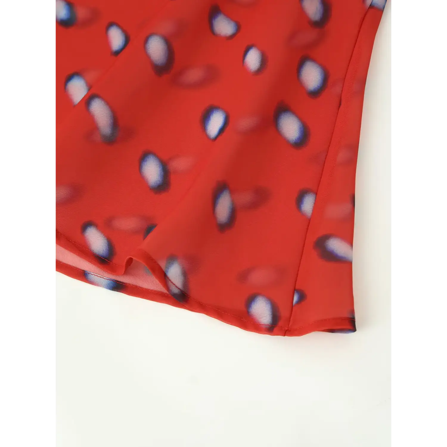 close view flared ruffle hem of red blur polka dot wrap skirt lightweight chiffon flowy bottom edge