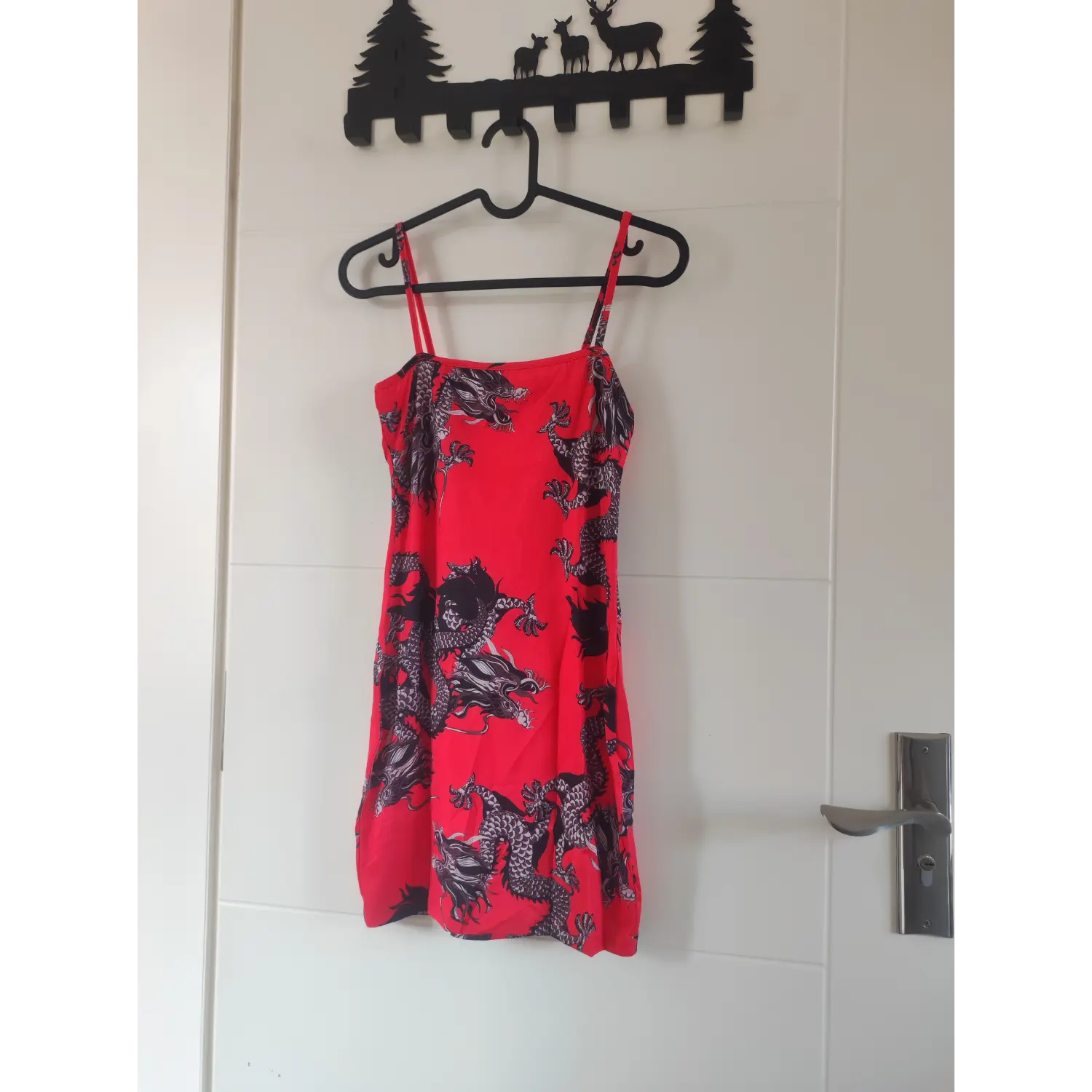 Front hanging view, red oriental dragon print spaghetti strap tight bodycon mini dress on hanger