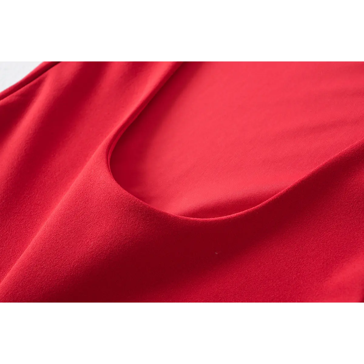 Close-up of the scoop back neckline and fabric texture on a red fit-and-flare dress.
