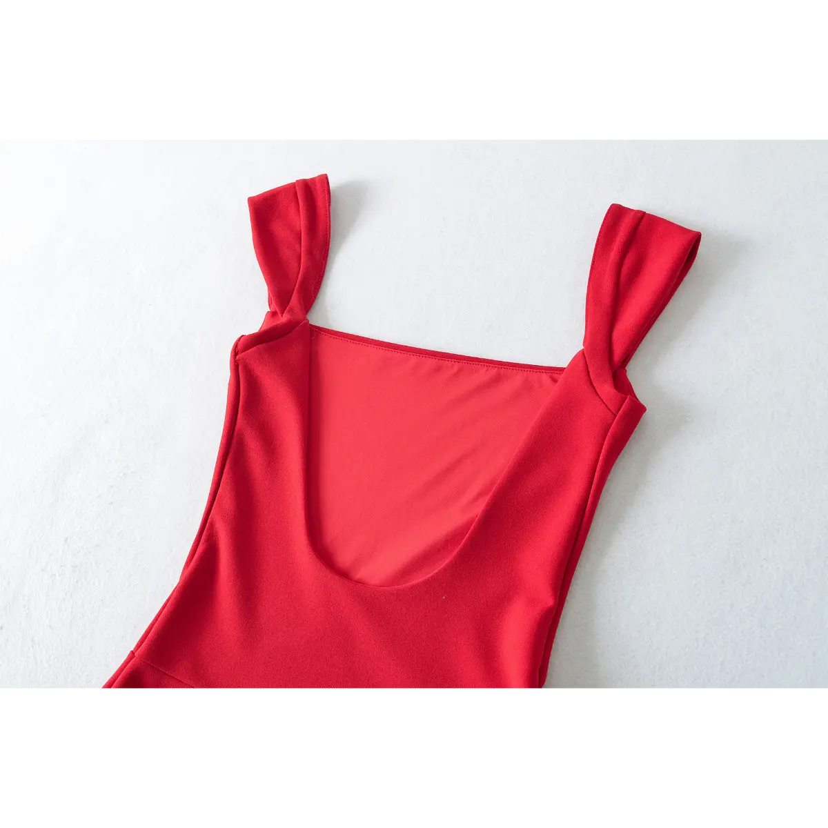 Close-up of the shoulder straps and scoop back on a red fit-and-flare dress.