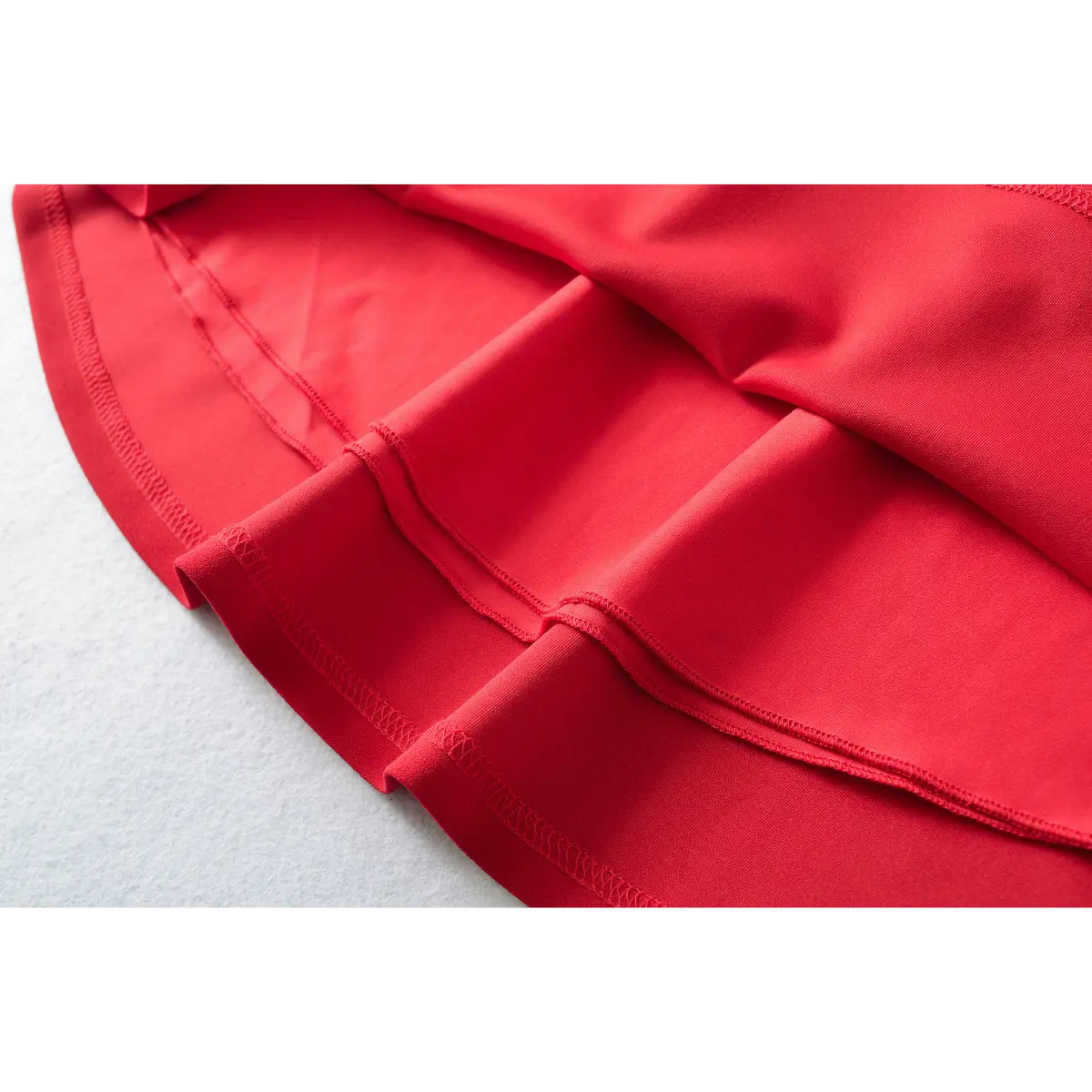 Close-up of the skirt hem and lining on a red fit-and-flare mini dress.