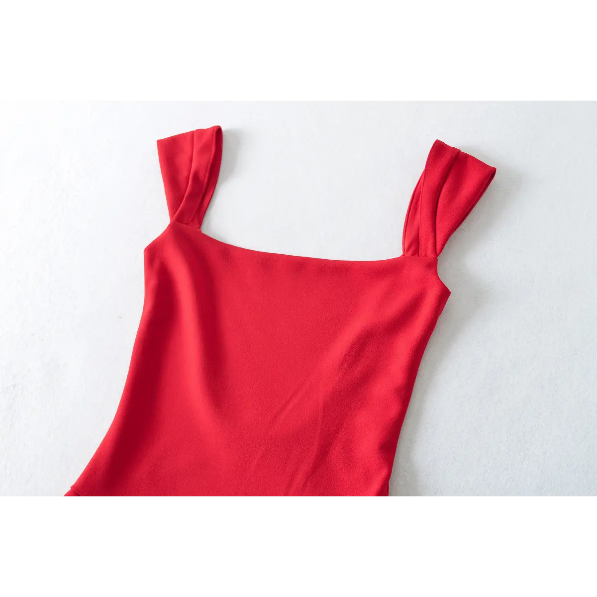 Close-up of the square neckline and shoulder straps on a red fit-and-flare dress.