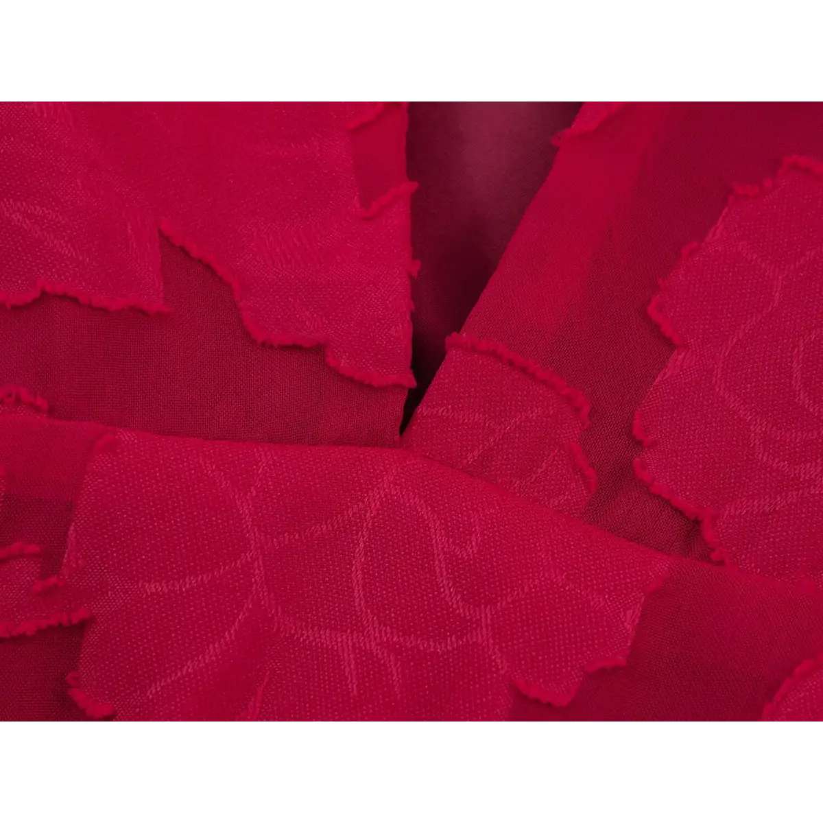 Close-up of the textured red floral appliqué fabric on a peplum top, showing the frayed edges and semi-sheer material.