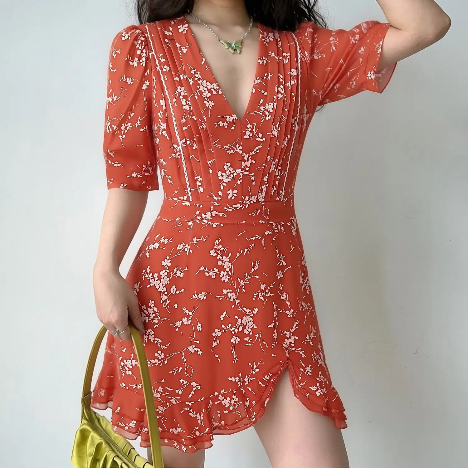 Lifestyle model photo, woman wearing red white floral V-neck chiffon mini dress